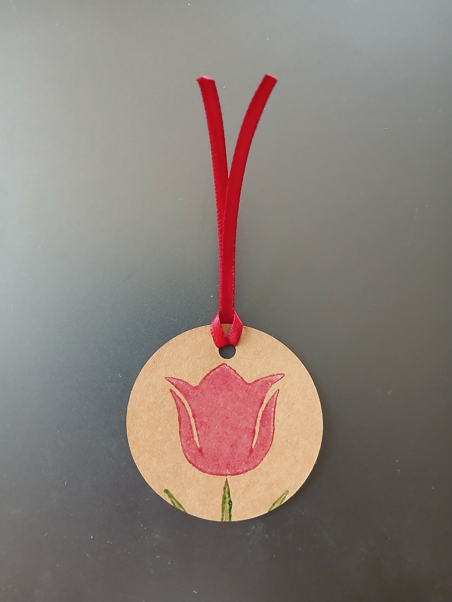 Tulip in Raspberry on round brown gift tag with ribbon