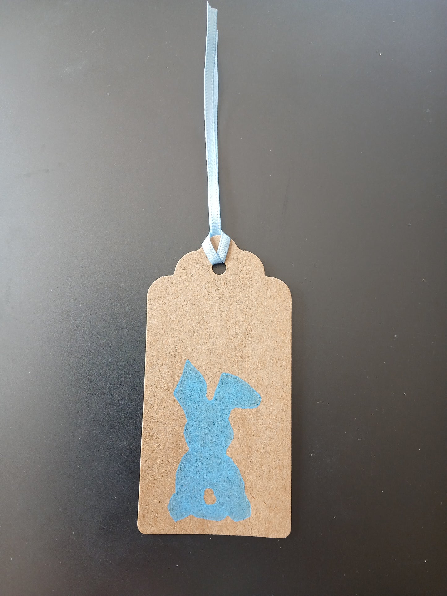 Bunny (small) in Blue on oblong brown gift tag with ribbon