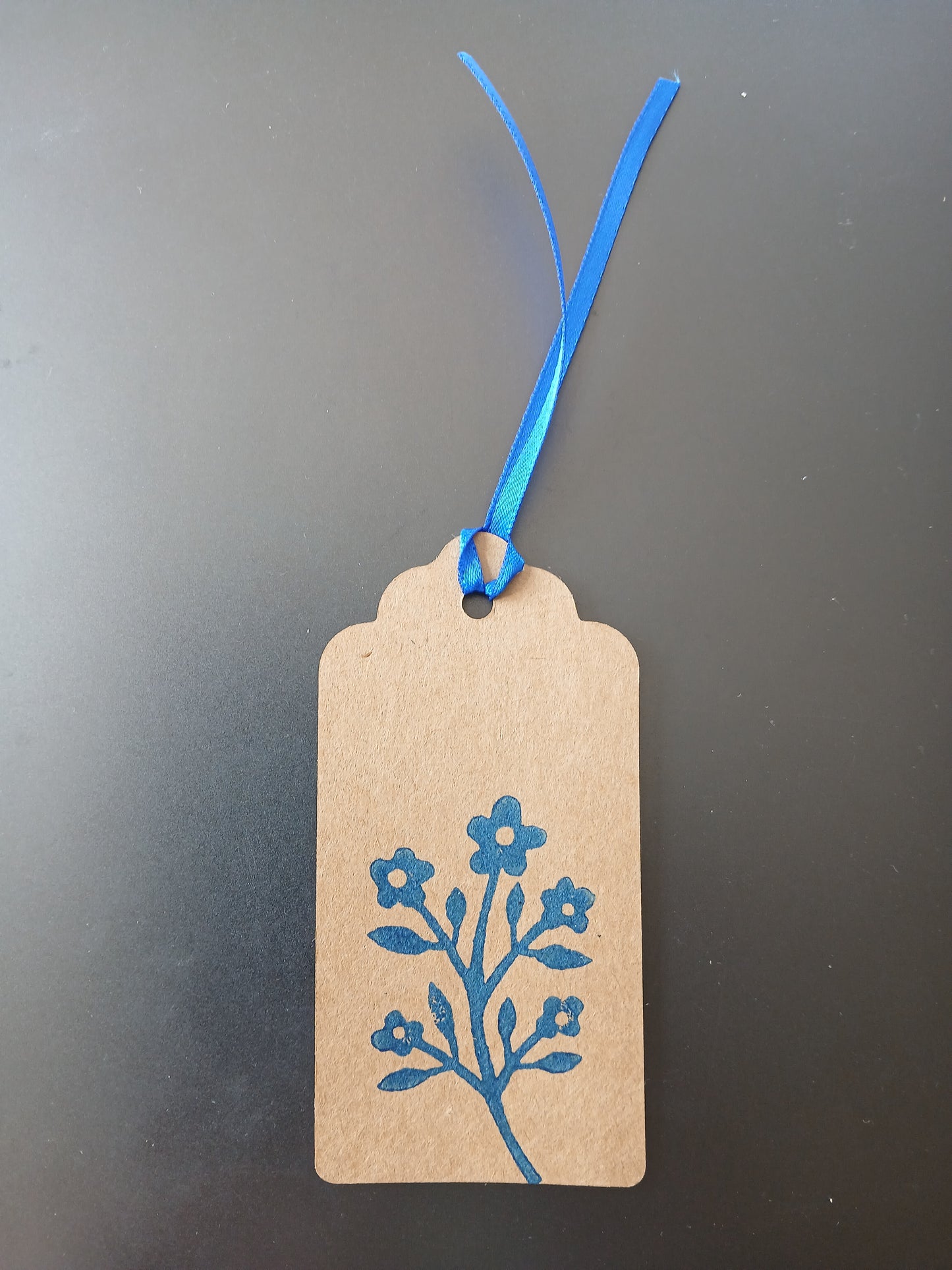 Flower Bunch in Brilliant Blue on oblong brown gift tag with ribbon