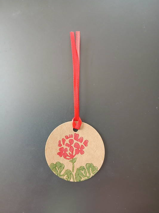 Geranium in Red & Green on round brown gift tag with ribbon
