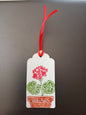 Geranium in Red, Green & Brown on oblong white gift tag with ribbon