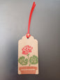 Geranium in Red, Green & Brown on oblong brown gift tag with ribbon