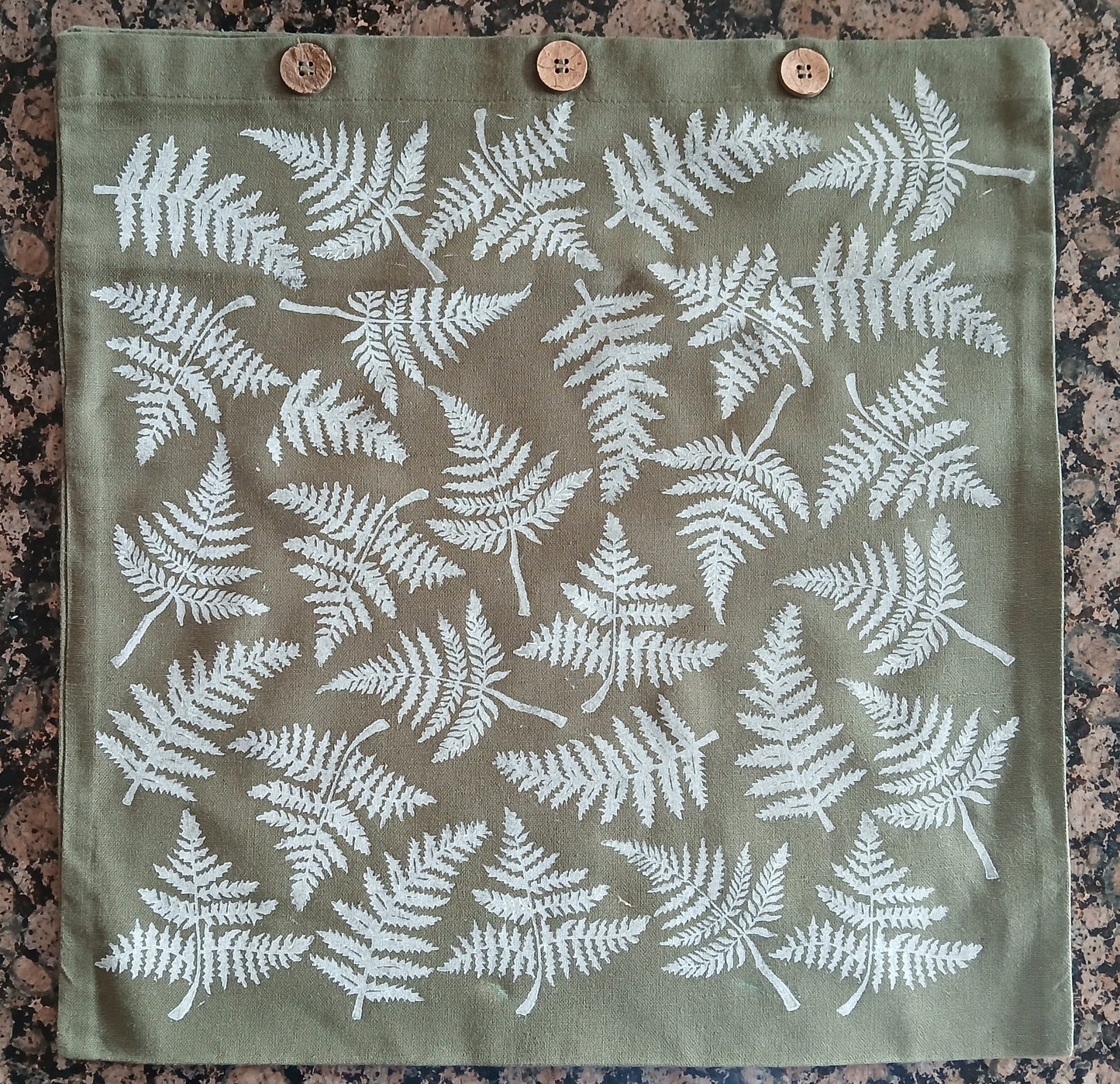Ferns in White on olive green cushion cover with buttons