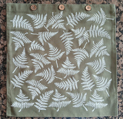 Ferns in White on olive green cushion cover with buttons