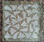 Ferns in White on olive green cushion cover with buttons