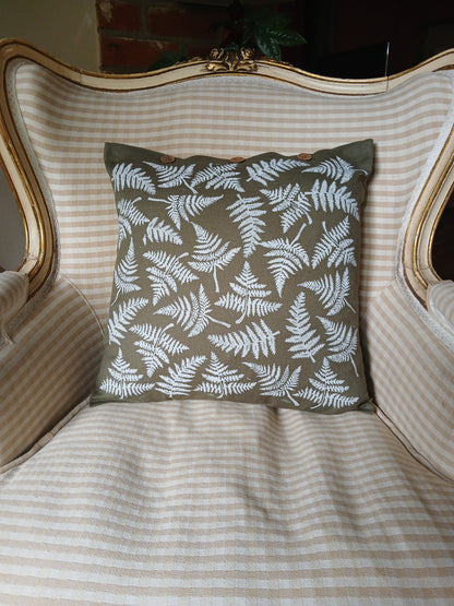 Ferns in White on olive green cushion cover with buttons