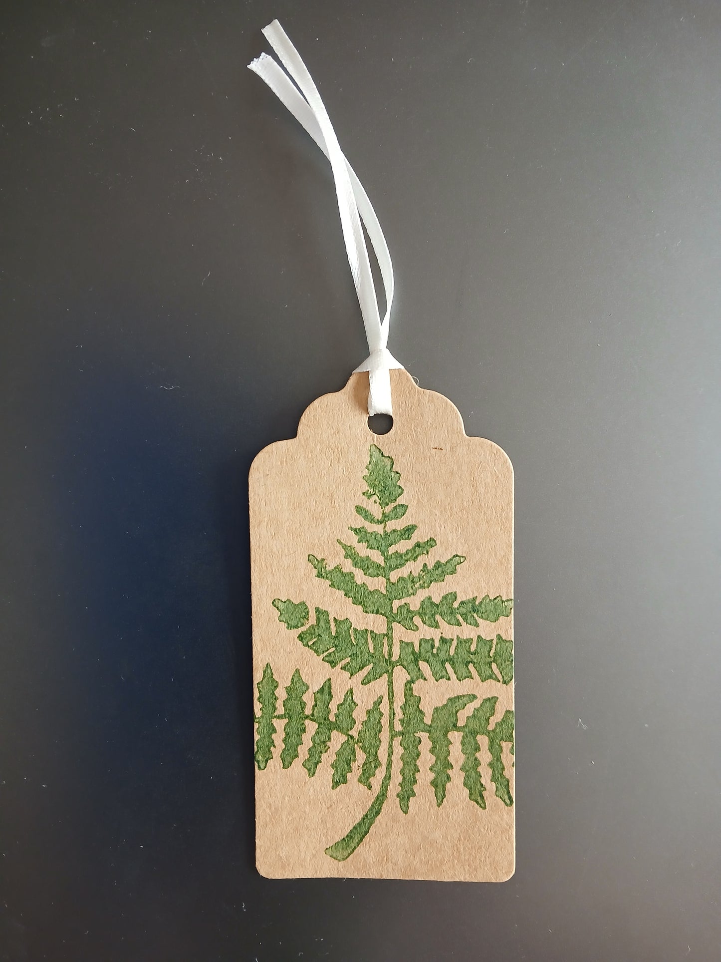 Fern 1 in Dark Green on oblong brown gift tag with ribbon